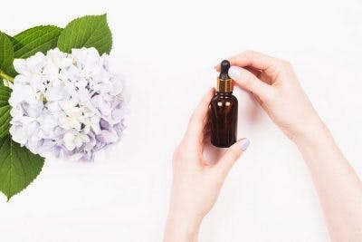 Mujer sosteniendo una botella ámbar de regalo de aceite de magnesio para pacientes con accidente cerebrovascular
