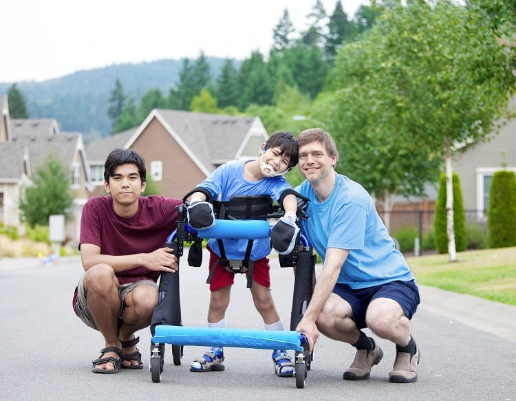boy with abnormal walking pattern called crouch gait due to cerebral palsy using a walker