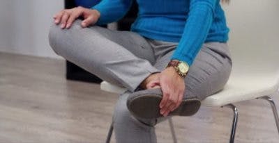 Maintenant, la physiothérapeute fléchit le pied vers le tibia avec l’aide de la main.  