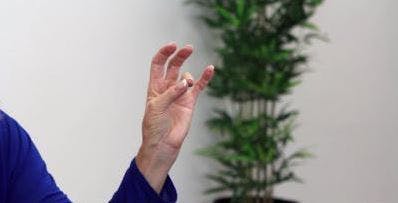 Der Therapeut berührt den Daumen, um den Finger für fortgeschrittene Handübungen zu ringen