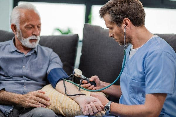 Doctor manually measuring blood pressure of patient who may have high blood pressure after head injury