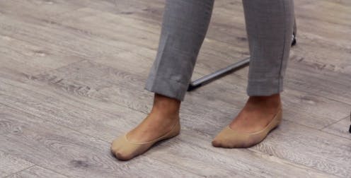 Une thérapeute pose les pieds pour effectuer un exercice de l'aversion de la cheville qui vise le pied tombant.
