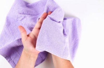 Person, die ein weiches Handtuch in den Händen zur sensorischen Umerziehung nach einem Schlaganfall hält