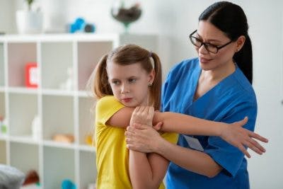 girl and physical therapist practicing exercises to manage spastic hemiplegia