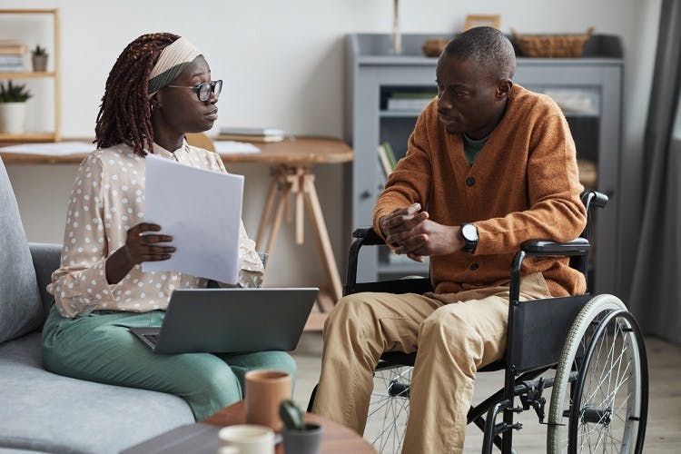 spinal stroke survivor sitting with caregiver learning more about the rare condition