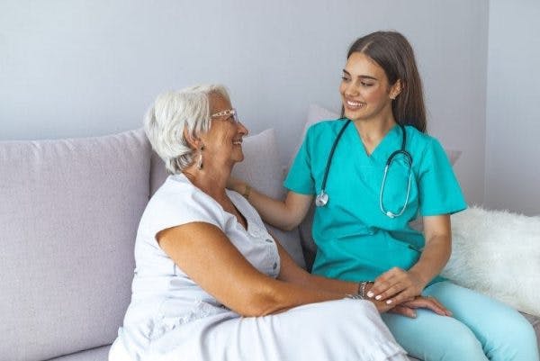 Une soignante conforte une patiente qui a subi des troubles sensoriels après un AVC, ce qui constitue le sujet de cet article.