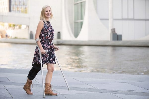 woman with cerebral palsy in the legs walking with crutches